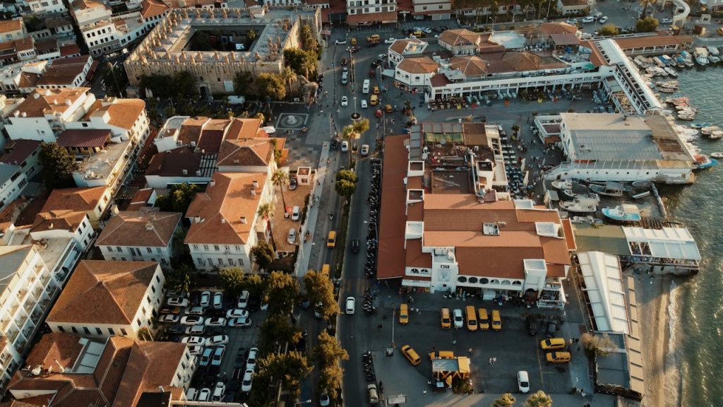 Stunning aerial view of Kuşadası, Türkiye, featuring architecture, streets, and waterfront at golden hour.